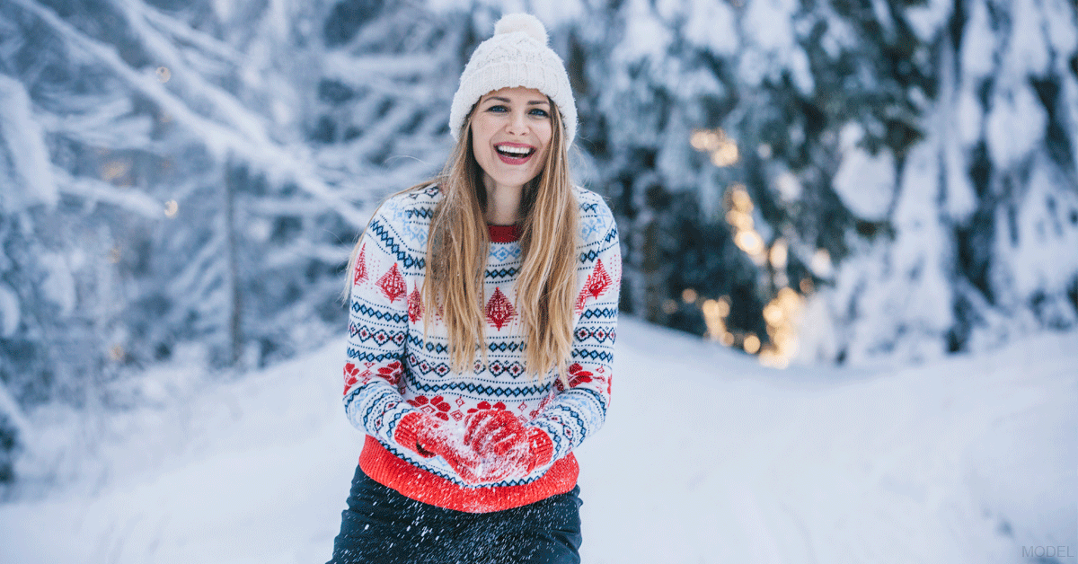 Woman playing in the snow following a mommy makeover