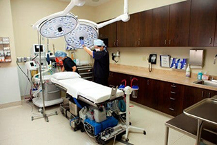 The Center for Cosmetic Surgery staff prepping operating table before a procedure.