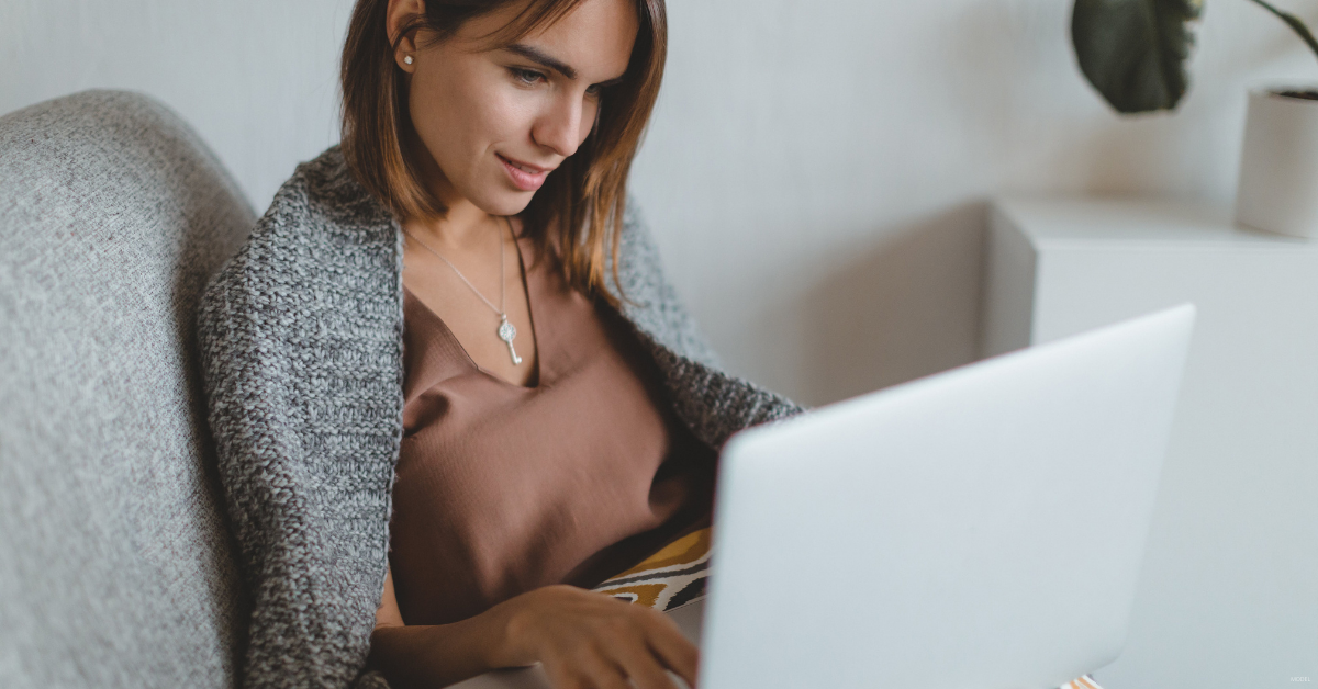 A woman researches breast augmentation on her computer.