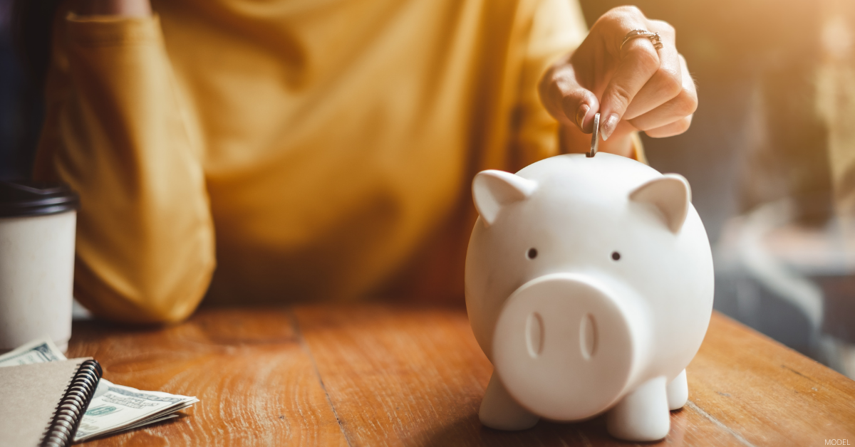 A woman puts money in a piggy bank. 
