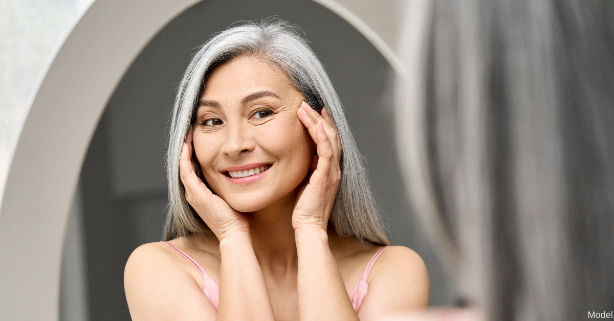 A mature woman looking in the mirror (model)