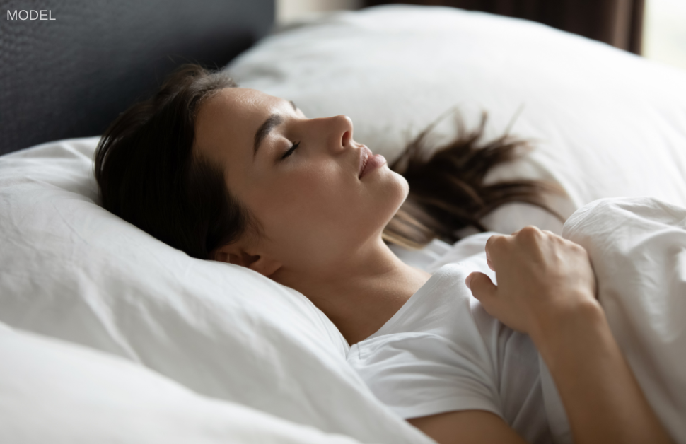 Woman (model) sleeping on her back. Resting on your back can help prolong the results of a breast lift.