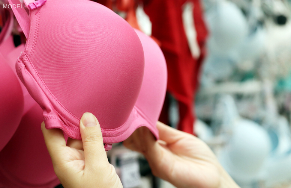 Woman's hands (model) shopping for a bra. Wearing a supportive bra helps to minimize breast sagging, or ptosis.